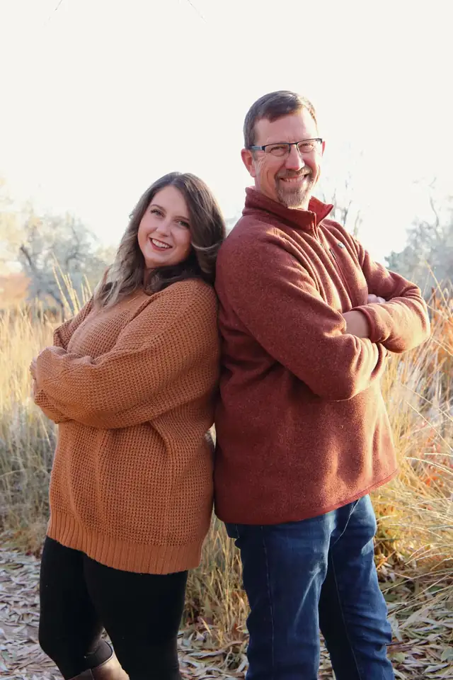 Michael Kuhn and his daughter Becca standing back to back outdoors